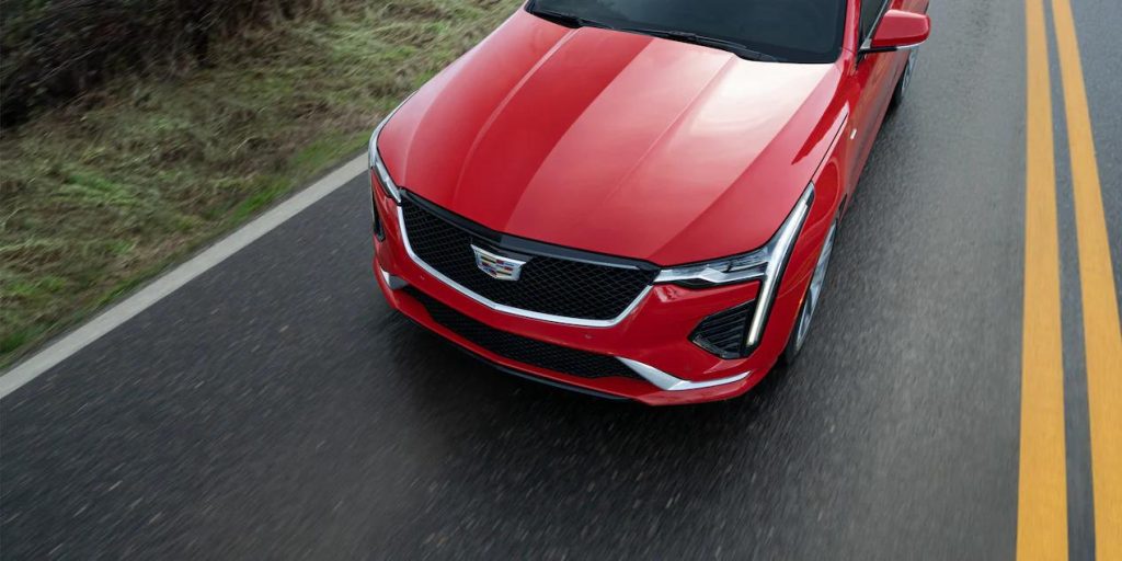 Top-down vie of a red Cadillac CT4 driving down the road.