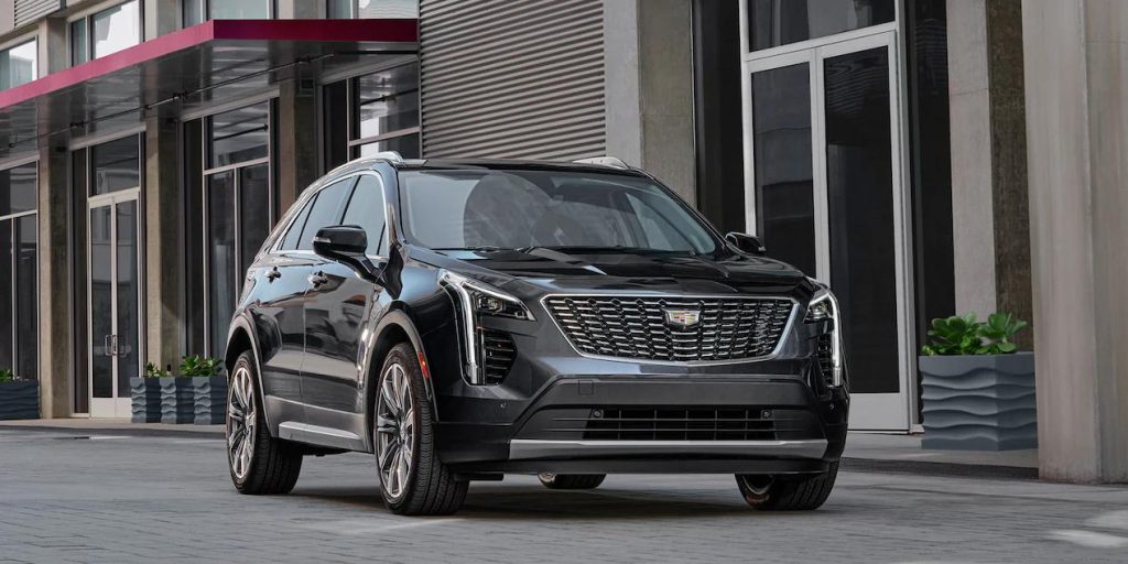 A black 2022 Cadillac XT4 driving down a city road.