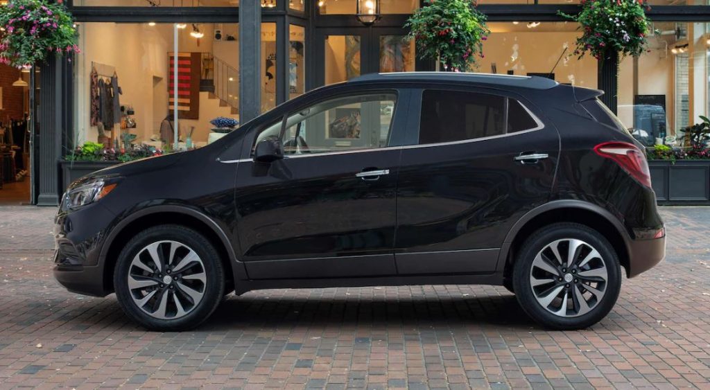 A black 2022 Buick Encore parked on a shopping street.