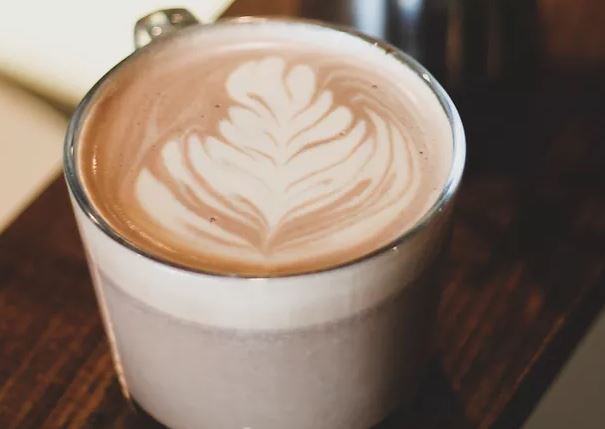 An up-close image of a latte with a coffee design.