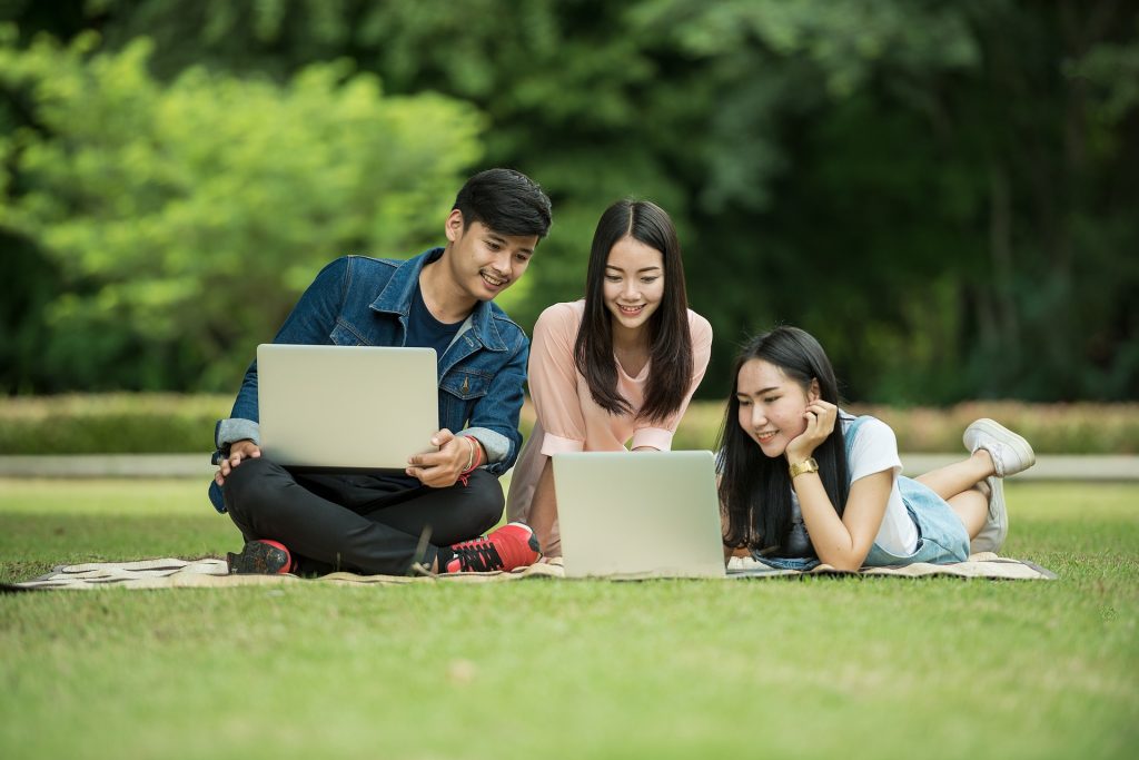 Students working on their laptop at the park.