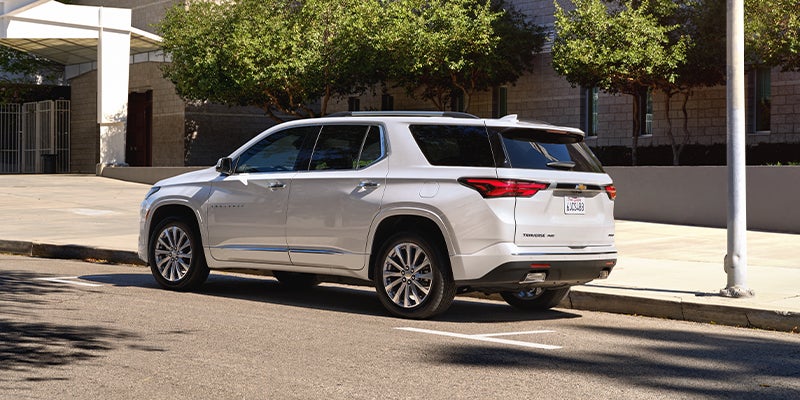A white 2023 Chevrolet Traverse parked on a curb.