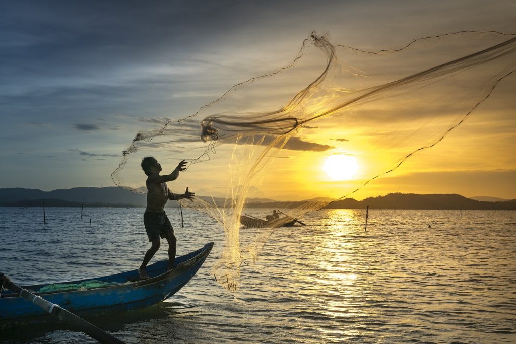 A person casting a fishing net out.